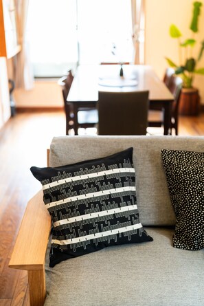 A living room with a grey sofa, a wooden bench, and two patterned cushions. - Ikebukuro - Large comfortable house in Tokyo (Tokyo)