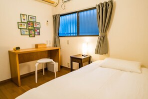 A room with a bed, a desk, a chair, a small table with a lamp, and a window with curtains. - Ikebukuro - Large comfortable house in Tokyo (Tokyo)