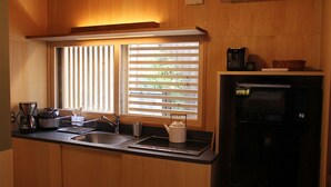 Une cuisine compacte équipée d’un évier, d’une machine à café, d’une bouilloire et d’un four à micro-ondes.