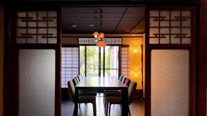 A traditional Japanese room with tatami flooring, a low table, and shoji screens.