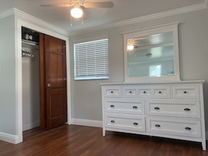 A room with a wooden door, a white dresser with multiple drawers, a ceiling fan, and a window with blinds. - Very Cute Cottage , in Bonita- Queen Bed + 2 Rollaway Beds. Near the Beach! (Bonita Springs)