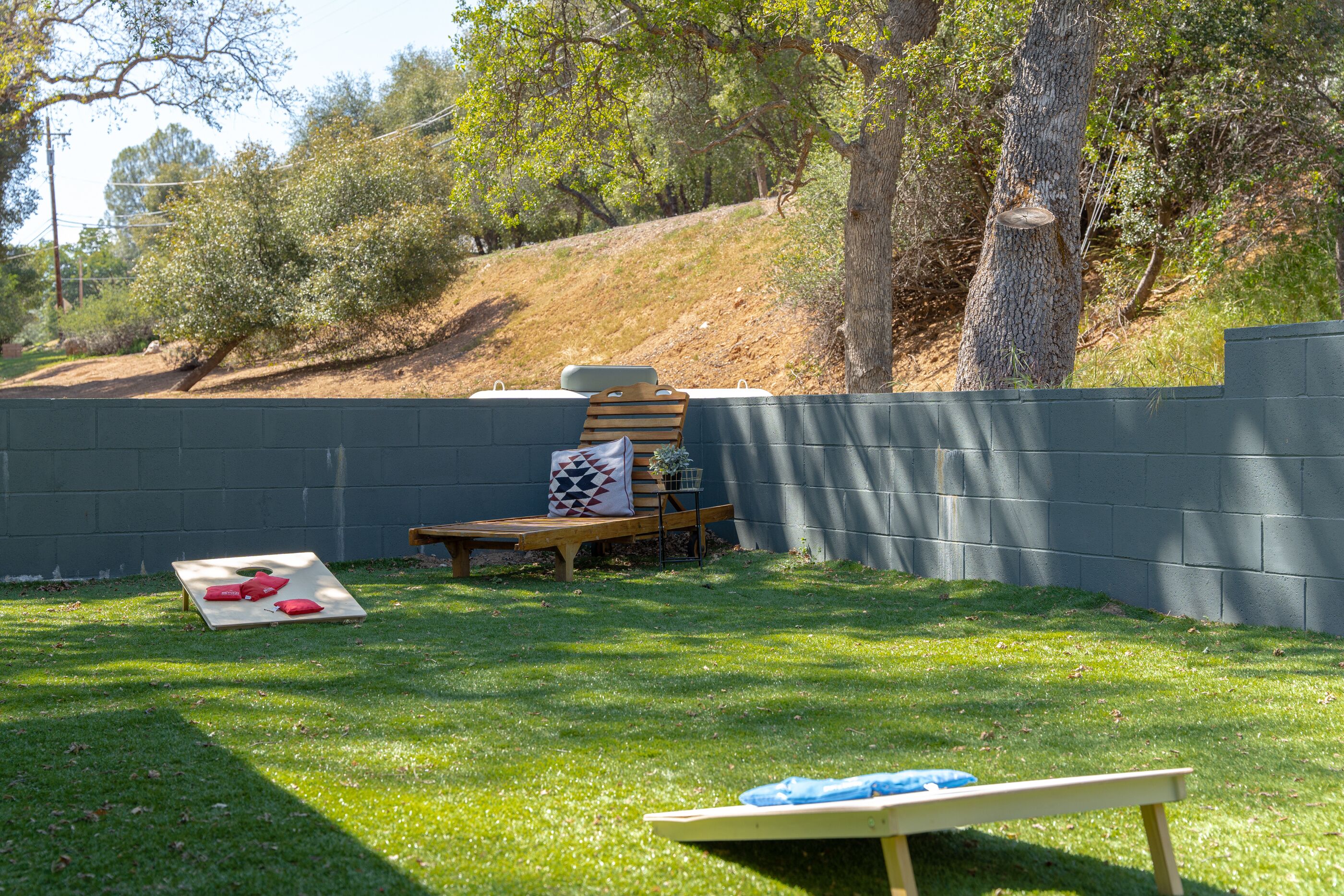 A backyard with a wooden bench, a small table, and a picnic setup.