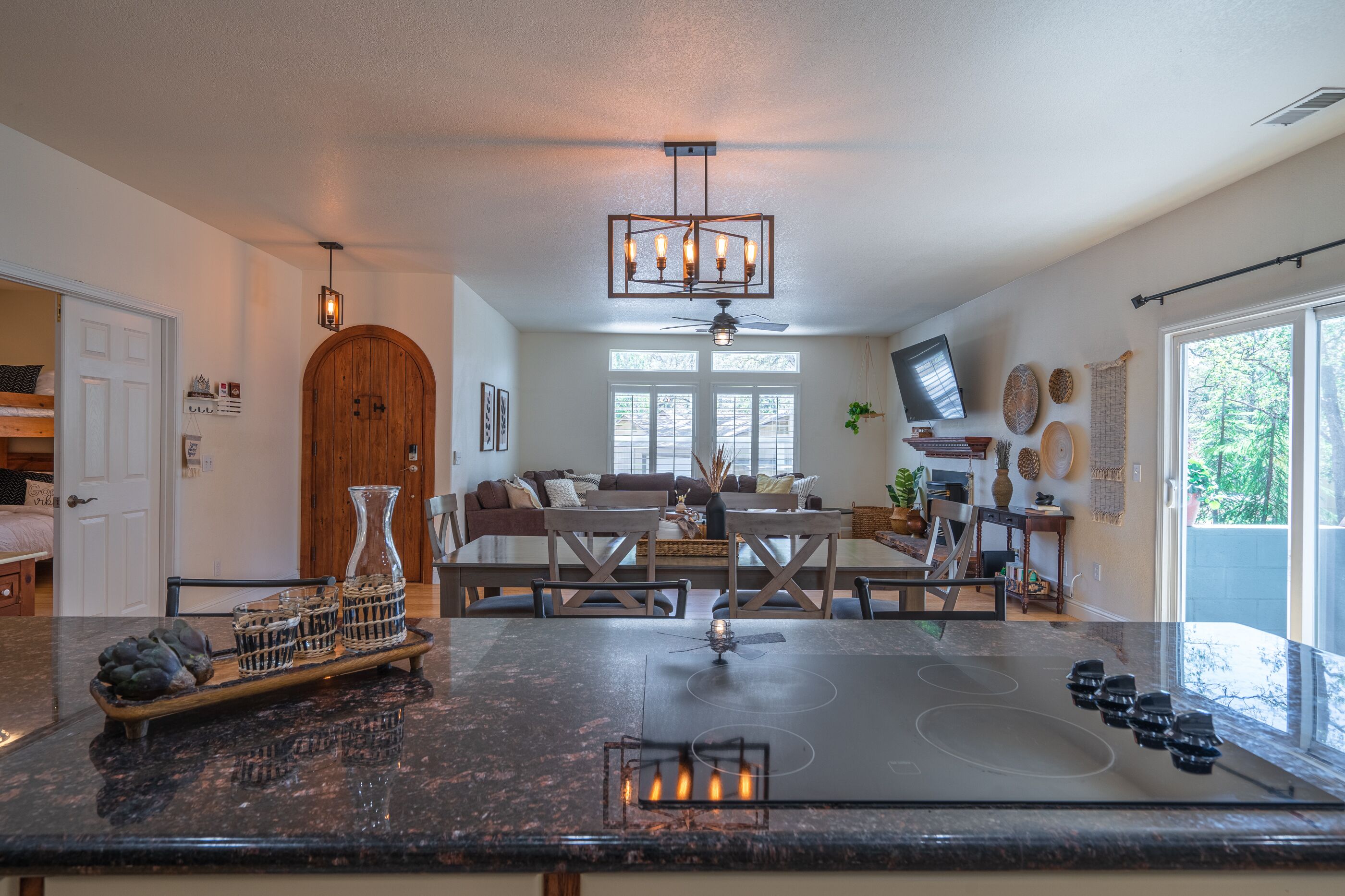 A modern kitchen with a central island, a ceiling fan, and a large window providing natural light.