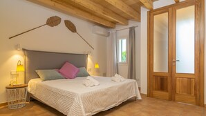 Ein Schlafzimmer mit einem Bett, Nachttischlampen, einem Fenster und einem Holzschrank.
