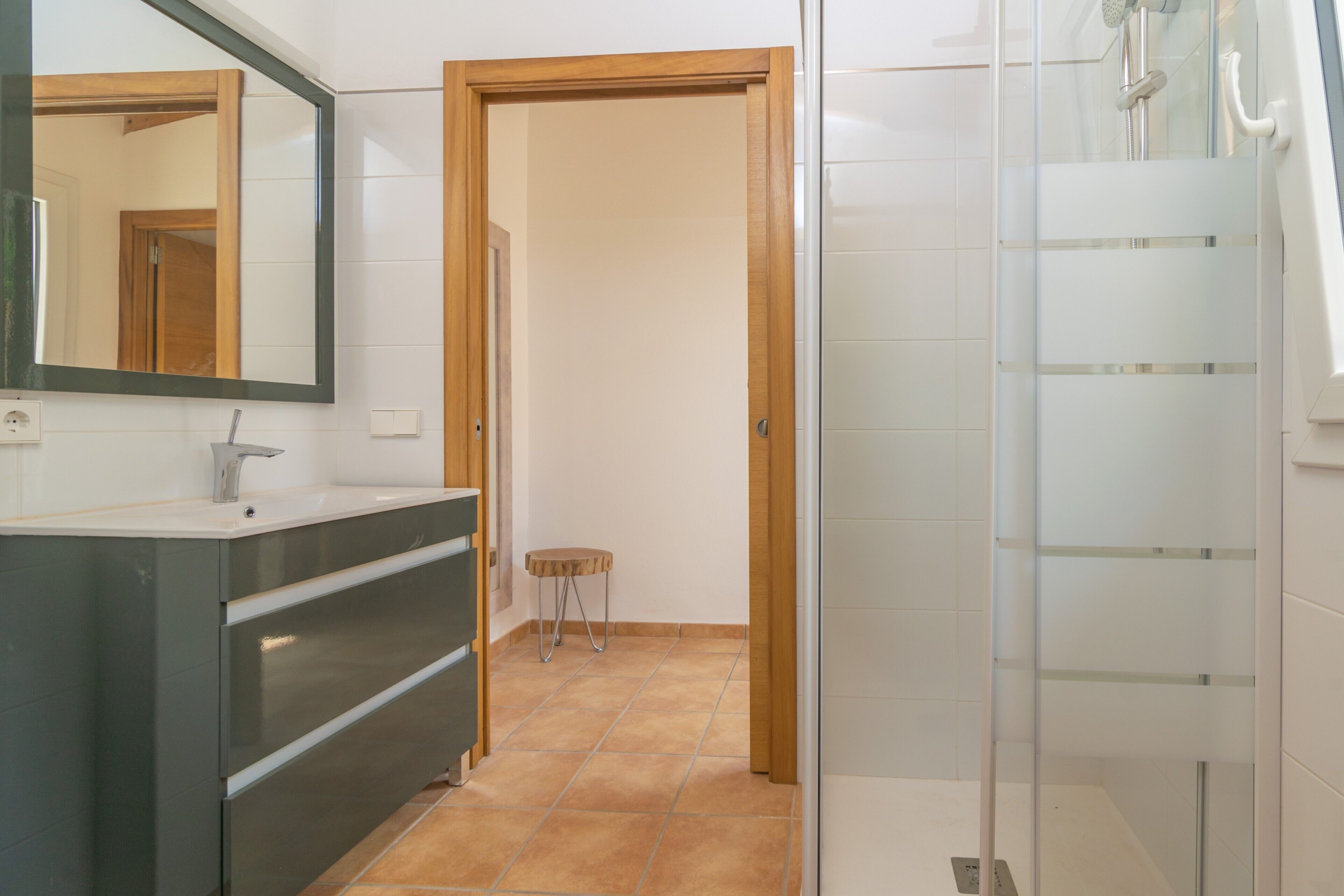Un baño con espejo, lavamanos y ducha.