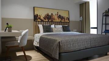 A modern bedroom with a bed, a desk, and a chair.