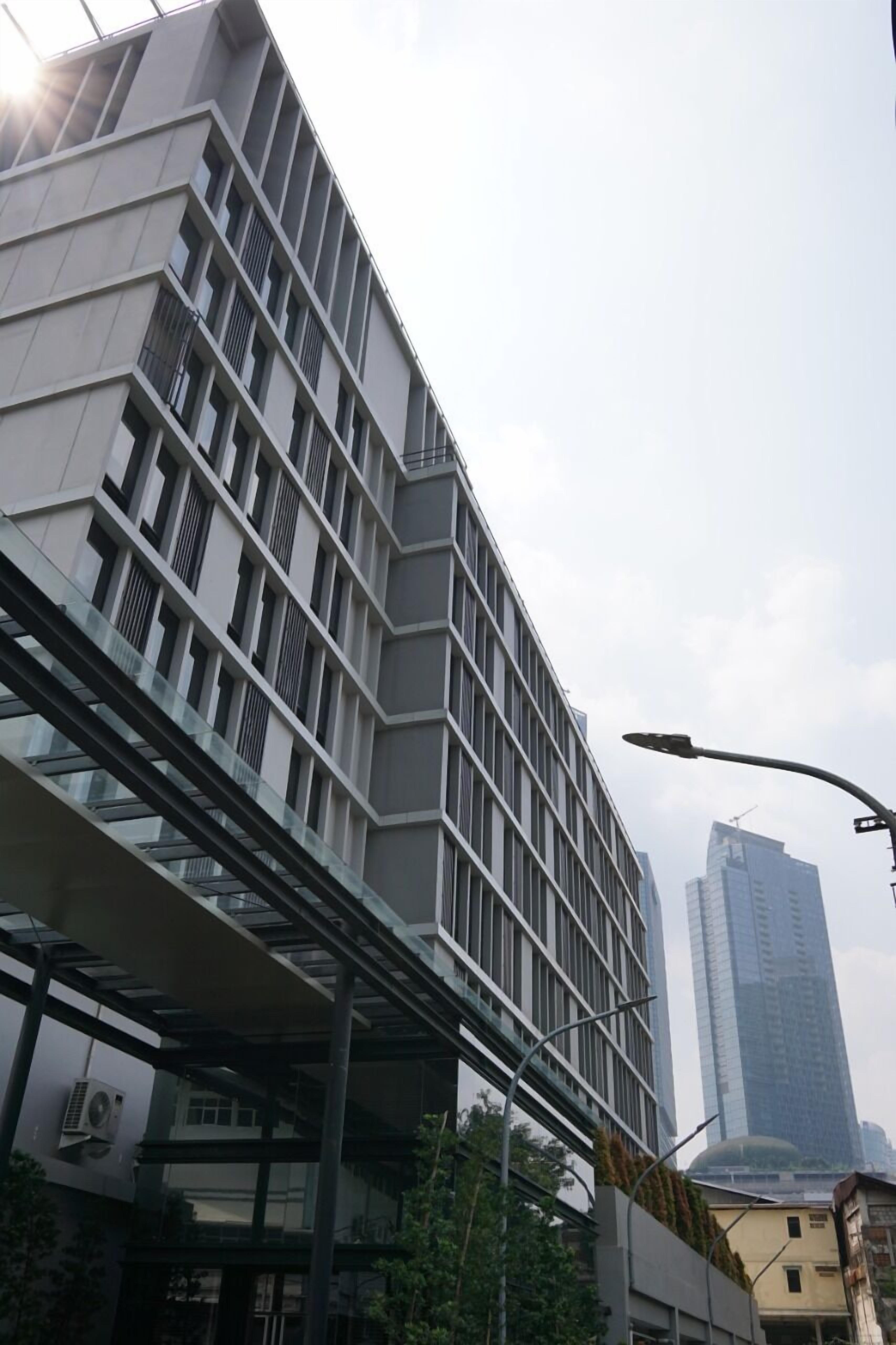 A modern building with a unique angular design, featuring multiple floors and large windows.