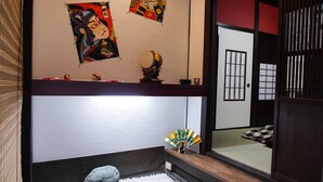 A traditional Japanese room with tatami flooring, a shoji screen door, and a decorative fan.