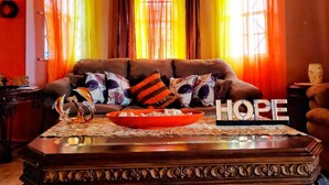 A living room with a brown sofa, a glass coffee table, and a bowl. The word "HOPE" is displayed on the table. - 2 Bed-Sleeps 4-Gated community-5 Min Town Centre (Florence Hall Village)