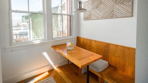 A corner room with a wooden bench, a table with a glass pitcher and wine glasses, and a geometric wall decoration. - Hot Tub;Mountain Views;steps from Arkansas River South Main (Buena Vista)