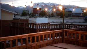 A wooden deck with benches and a white cooler, overlooking a residential area with houses and mountains in the background. - Hot Tub;Mountain Views;steps from Arkansas River South Main (Buena Vista)