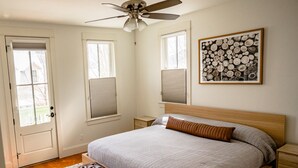 A bedroom with a bed, a bench, a ceiling fan, a window, and a wall-mounted artwork. - Hot Tub;Mountain Views;steps from Arkansas River South Main (Buena Vista)