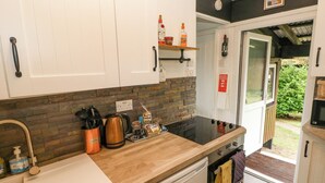 Una cocina moderna con armarios blancos, encimera de madera, lavavajillas y estufa negra.