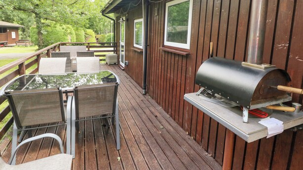 Una terraza al aire libre con una parrilla y zona de estar.