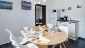 Une cuisine moderne avec des meubles blancs, un four à micro-ondes et une machine à café.