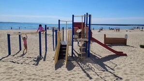 En strandlegeplads med rutsjebaner og klatrestrukturer.