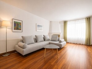 A modern living room with a grey sofa, a small round table, and a floor lamp.