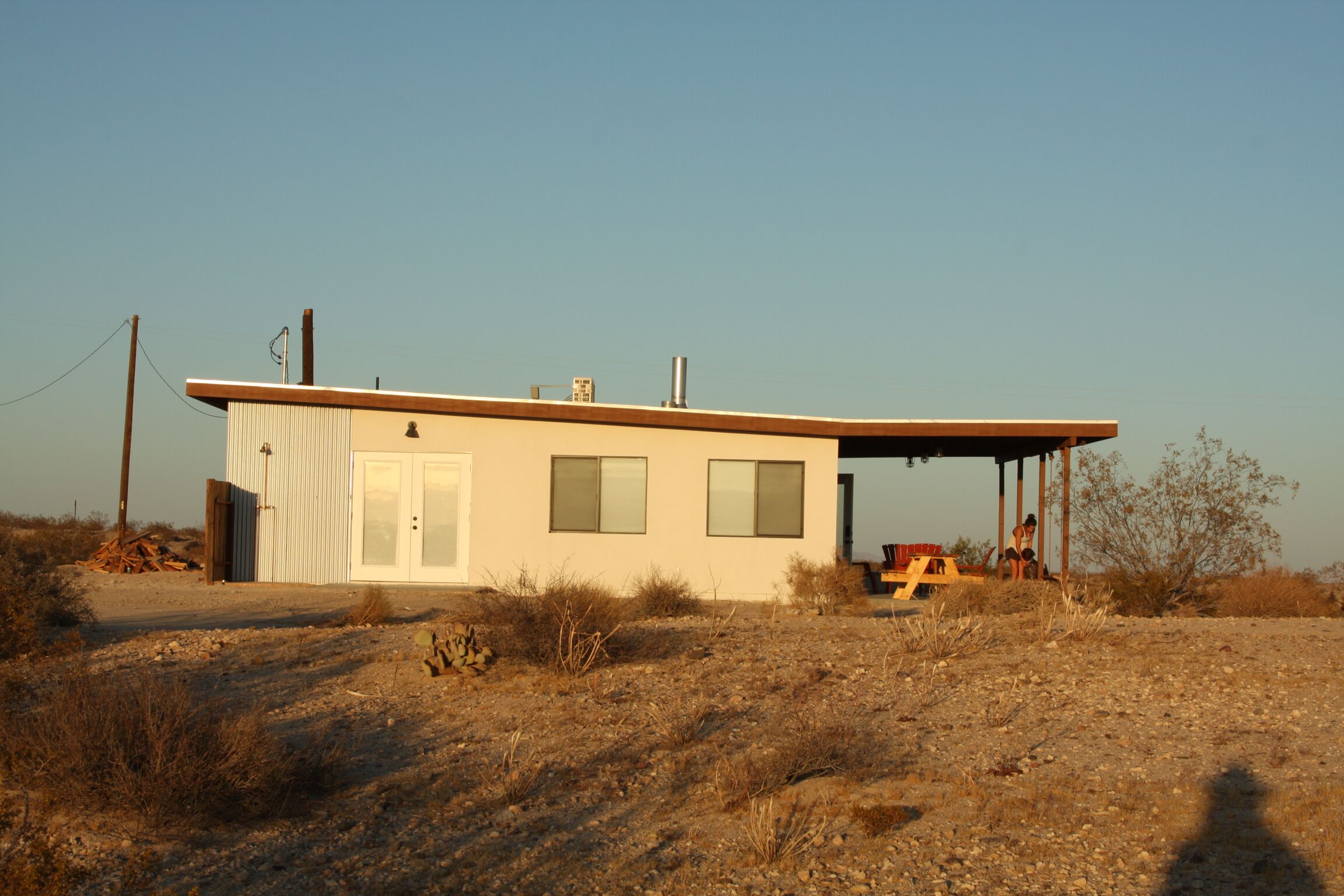 A single-story building with a flat roof, a door, and two windows.