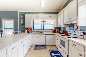 Enjoy cooking in this well-equipped kitchen with a central island, window, and modern appliances.