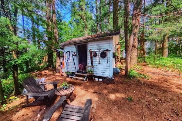 The Stabbin Cabin - Adirondack Chair and Table with BBQ Grill and Hammock just out front. Mini Fridge on left side of Cottage
