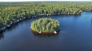 An aerial view of a lake surrounded by dense forest, with a small island in the center.