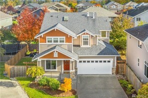 Stunning two-story home with a garage, brick and siding exterior, and a charming front porch.