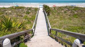 A wooden boardwalk leading to a beach with umbrellas and chairs. - Oceanfront, Amazing Ocean Sunrise and Intracoastal Sunset View, Pool, Elevator, $300 in Free Tickets (St. Augustine)