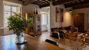 A dining area with a wooden table, chairs, a cabinet with glass doors, and a sofa.