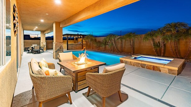 Um pátio externo com piscina, área de estar e lareira.