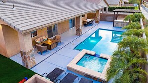 Um imóvel residencial com piscina, mobiliário de jardim e vista para montanhas.