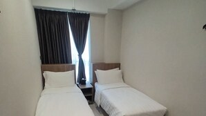A hotel room with two single beds, a small table, and a window with curtains. - WE Hotel Kowloon (Kowloon)