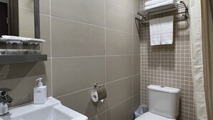 A bathroom with a sink, toilet, and shower area. - WE Hotel Kowloon (Kowloon)