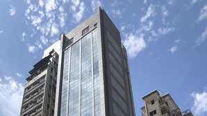 A high-rise building with a modern glass facade and a flat roof. - WE Hotel Kowloon (Kowloon)