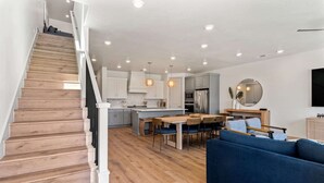 Une cuisine moderne avec un plancher en bois, un coin repas et un canapé bleu.