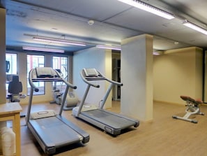 Una palestra attrezzata con tapis roulant, cyclette e vogatore.