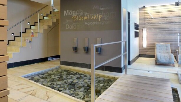 Ein modernes Interieur mit Steinfliesenboden, einer Treppe und einer Wand mit Text.