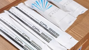 A wooden surface with several packages of Dr. Razor toothbrushes. - Gyeongju Jang (Gyeongju)