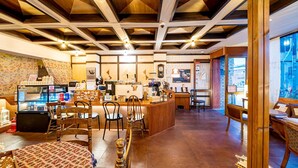 A cozy cafe with wooden furniture, a counter with a coffee machine, and a view of the street outside. - Gyeongju Jang (Gyeongju)