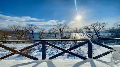 A snow-covered landscape with a metal railing in the foreground.