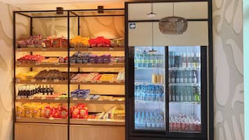 A vending machine stocked with snacks and beverages, including chips, chocolates, and bottled drinks.