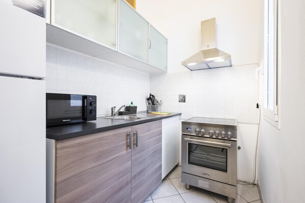 A modern kitchen with a microwave, sink, and stainless steel oven.