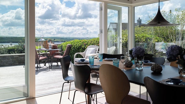 Un comedor con una mesa preparada para dos, con vistas a un paisaje pintoresco.