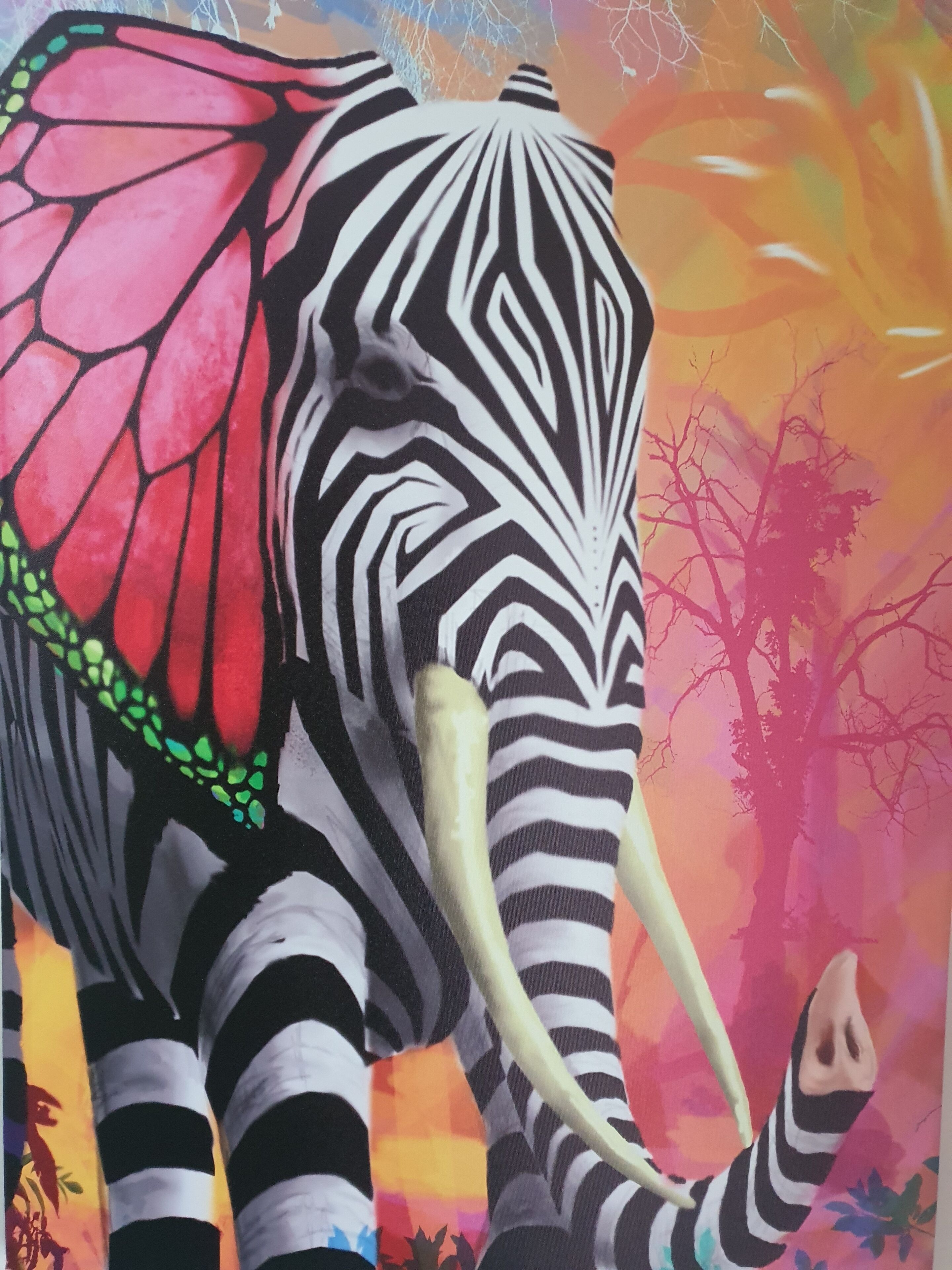Een olifant met een zebrapatroon, met een rode vleugel en slagtanden, voor een kleurrijke achtergrond met bomen en een zonsondergang.