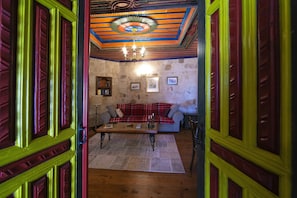 Una habitación acogedora con un sofá de cuadros rojos, una mesa de centro de madera y una alfombra estampada.