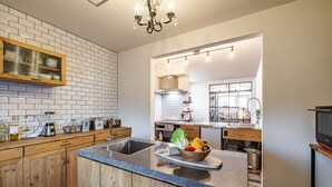 A modern kitchen with a central island, wooden cabinets, and a built-in stove. - Antiques Inuyama (Inuyama)
