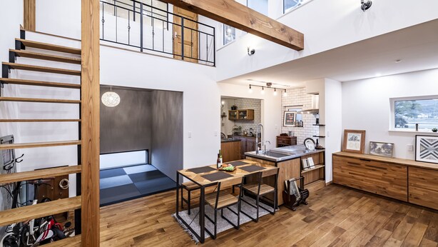 A spacious loft with a wooden staircase, a mezzanine level, a kitchen with a view, and a dining area with a table and chairs. - Antiques Inuyama (Inuyama)