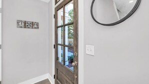 A hallway with a wooden door, a mirror, and a wall-mounted light switch. - BRAND NEW LISTING DISCOUNT - The Crow's Nest at Turtle Bay Marina (Old hickory)