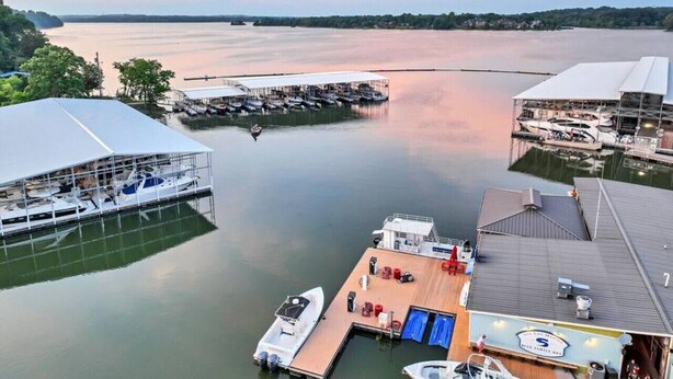 Un port de plaisance avec des bateaux amarrés, un hangar à bateaux couvert et un bâtiment doté d’un toit plat.