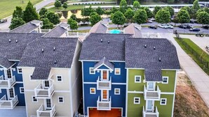 Une rangée d’immeubles résidentiels à plusieurs étages, avec une allée incurvée et un parking.