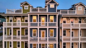 Un immeuble résidentiel à plusieurs étages, doté de balcons et d’une entrée centrale.